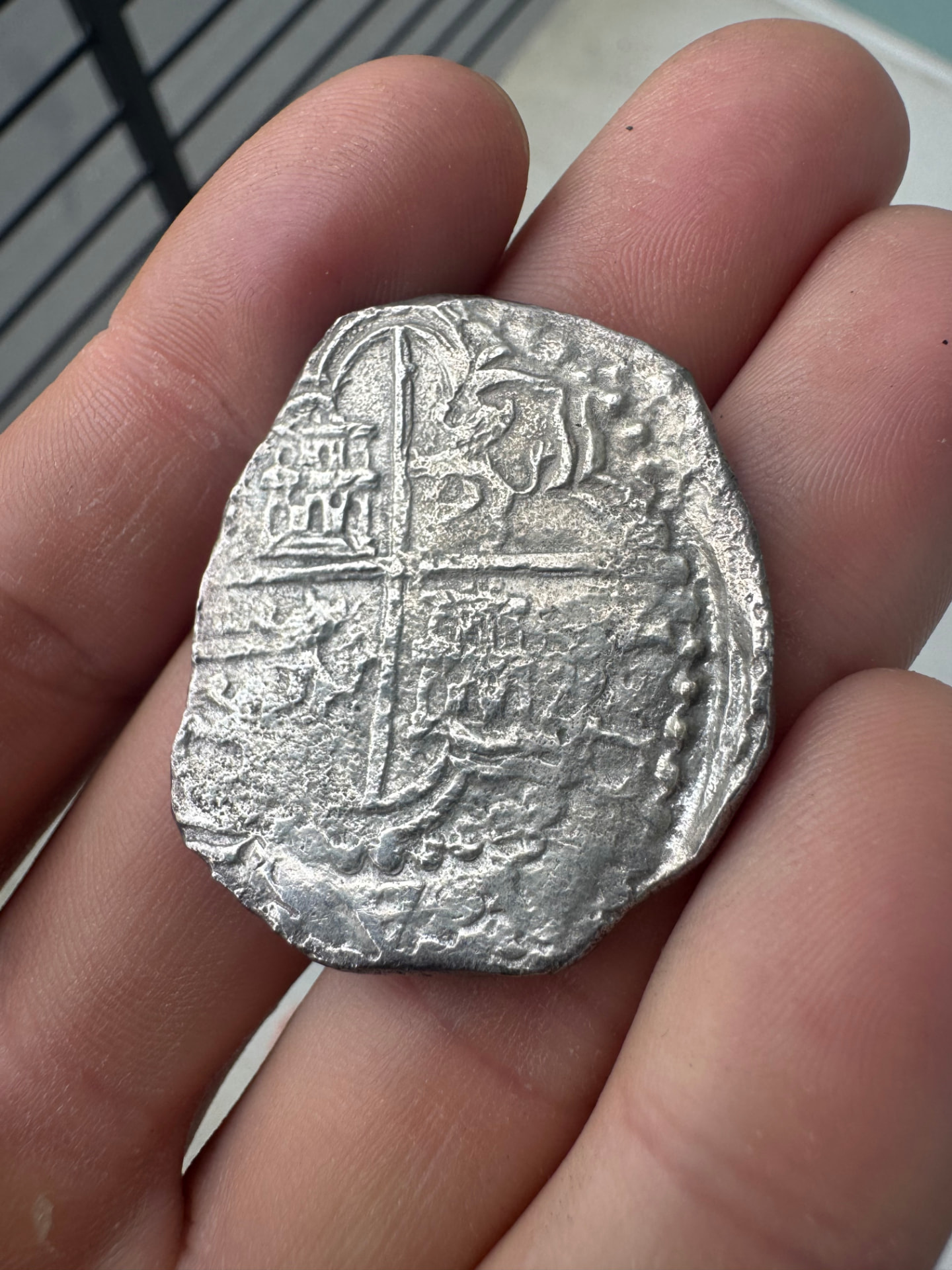 Silver Atocha 8 reales cob held in a hand