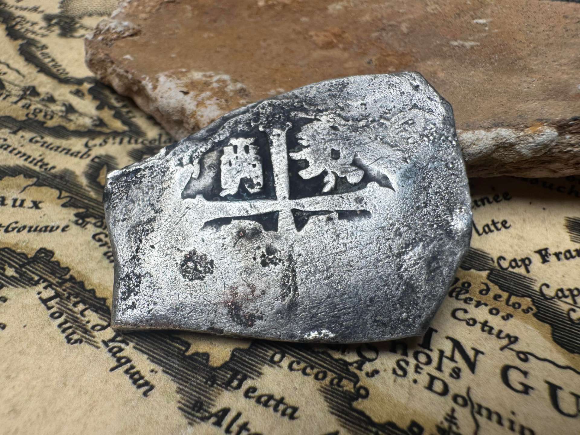 Obverse cross of the 1715 Fleet Mexico 8 reales silver cob on an antique chart