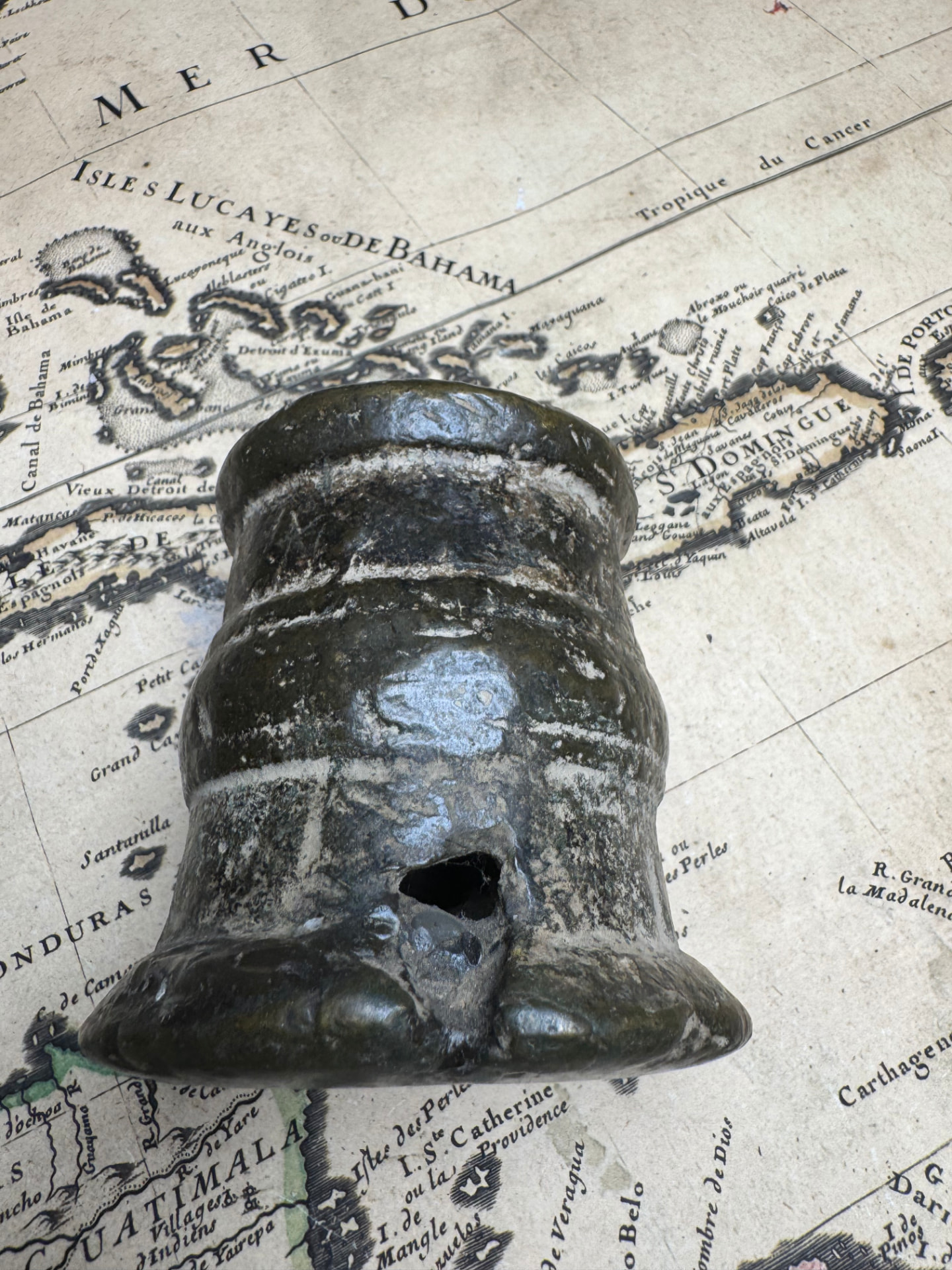 Side view of the bronze thunder mug showing the vent opening and dark patina