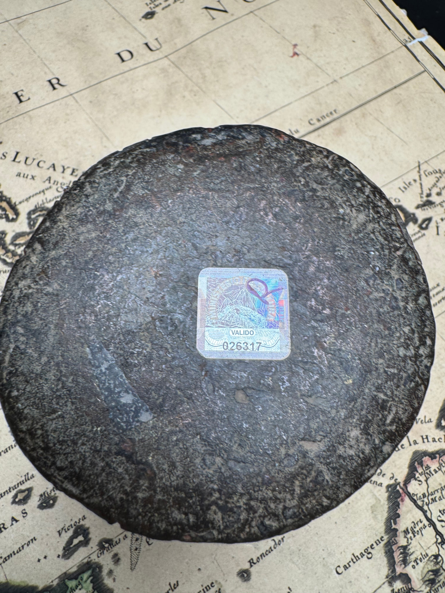 Base of the bronze thunder mug resting on an antique chart