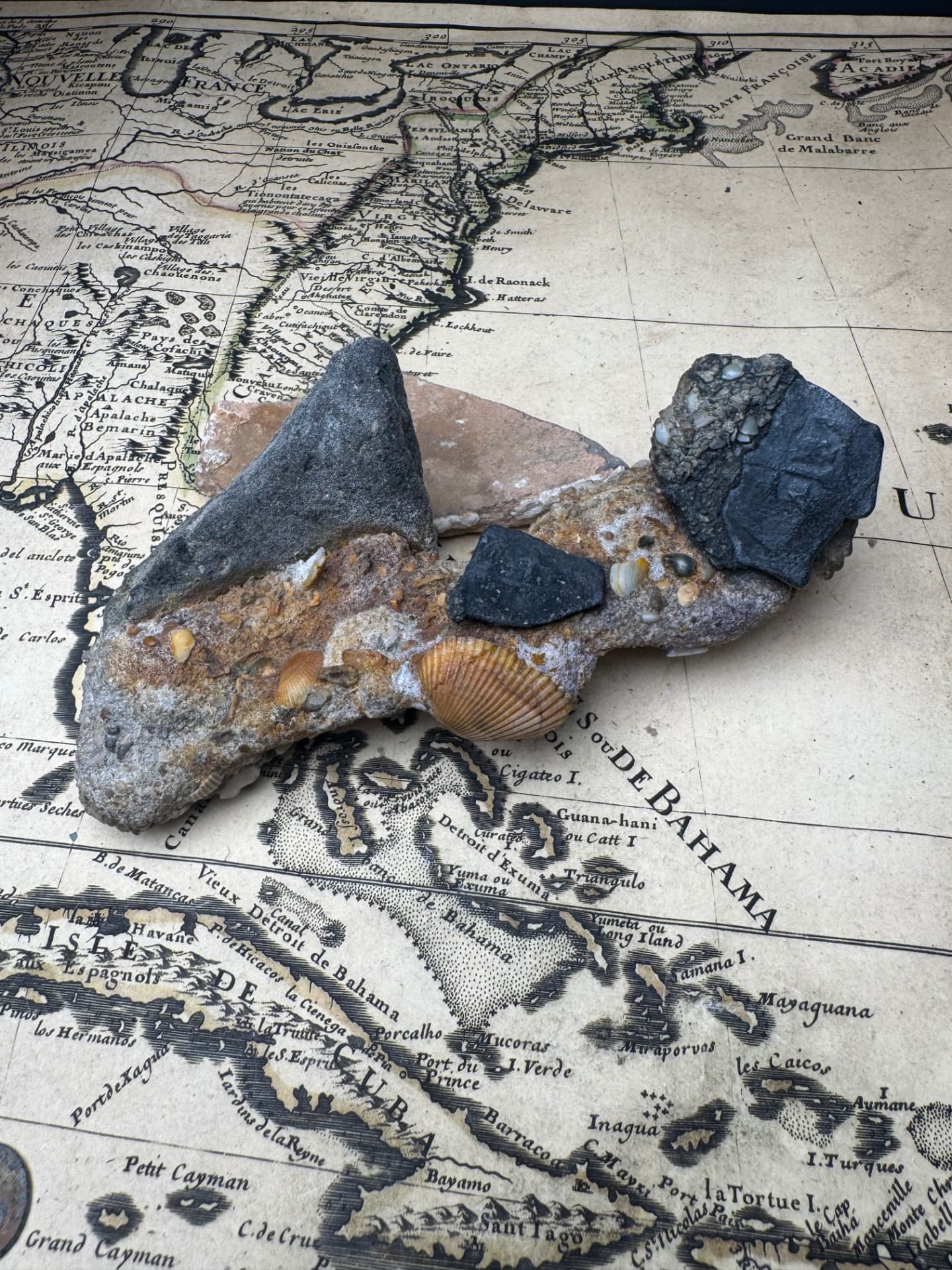 1715 Fleet shipwreck conglomerate with iron spike, silver cobs and pottery on an antique chart