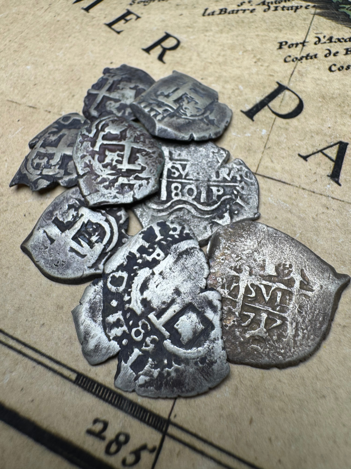 Hand-struck 1 reale silver cobs showing crosses and shields