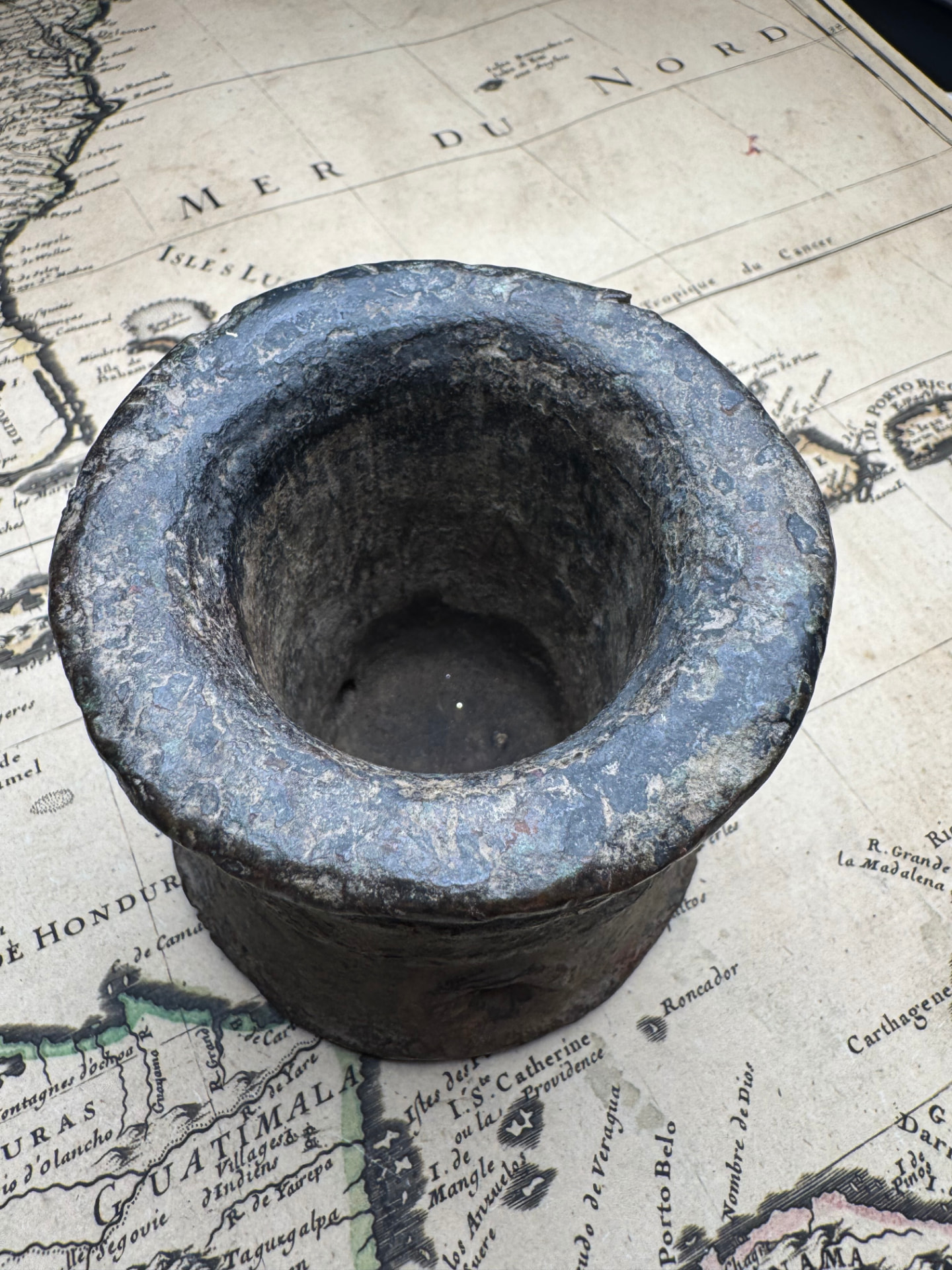 Top view down the bore of the bronze thunder mug showing heavy patination