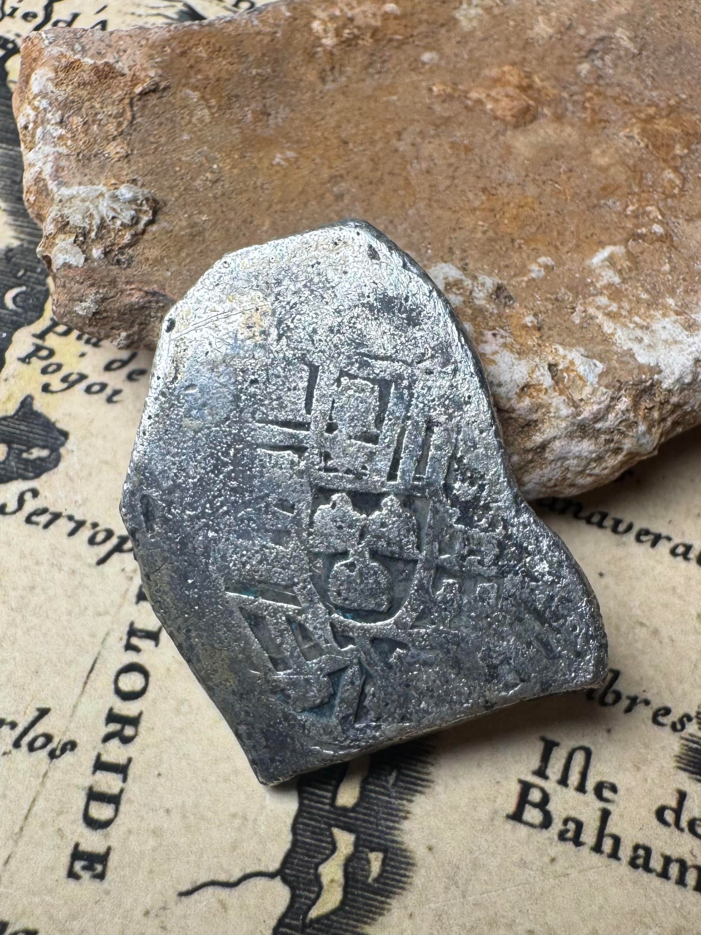 Shield side of the 1715 Fleet 4 reales silver cob on an antique chart
