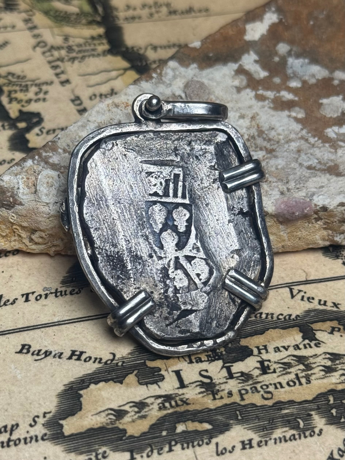 Reverse of the 8 reales cob pendant showing the crowned Habsburg shield